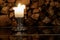 Candle with logs on a background and reflection on a floor.