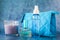 Candle perfume and cosmetic bag in shallow depth of field on blue background