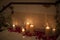 Candle surrounded by red rose petals with dreamy reflection