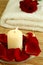 Candle, towel and petals of rose.