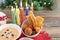 Candlelight Day. Typical Colombian food. BuÃ±uelo, custard and flakes with candles and Christmas tree in the background. Colombian