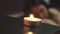 Candles burn in a massage salon in front of a lying girl