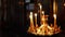 Candles burning in the altar in front of the Holy icons in the Christian Orthodox Church