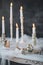 Candles on the decorated old fashioned table with silver