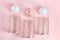 Candles in the form of balls of white and copper color. metal candlesticks on pink background. modern home decor. simple flat