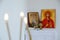 Candles in front of icons in the Orthodox church. A burning wax candles, cross and icons in monastery. Christian religion. Altar i