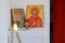 Candles in front of icons in the Orthodox church. A burning wax candles, cross and icons in monastery. Christian religion. Altar i