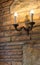 Candlestick with lamp on brick wall in ancient building. Medieval interior. Stone and brick old house.