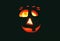 Candlestick pumpkin with a burning candle inside on dark background, symbol of Halloween