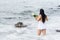 Candomble admirers are seen on top of a rock on the beach, paying homage to Iemanja with gifts