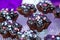 Candy bar with glazed muffins and sprinkles on purple background.
