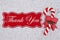 Candy cane on plush gray material with text Thank You