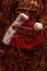 Candy canes on a red Christmas hat among garlands on a wooden table top view