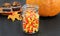 Candy corn in a rustic mason jar. Pumpkin and cupcakes in the b