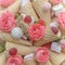 Candy, marshmallow, pastille, waffle cones and pink roses as background or backdrop