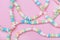 Candy necklace on pink pastel colored background.