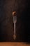 Candy truffle on a dessert fork levitating on a black background. Candy on a beautiful antique fork with a pattern