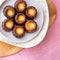 CanelÃ©s de Bordeaux on a white plate and pink napkin