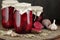 Canned beetroot in glass jars on rustic wooden background, closeup, food storage solution