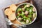 Canned cod liver salad with fresh arugula and sun-dried tomatoes served with toast close-up in a bowl. Horizontal top view