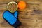 Canned dog food in bowl, ball toy and pet grooming glove on wooden background. Top view, copy space. Pet care concept