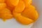 Canned mandarin oranges on a white plate close view