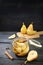 Canned pears with cinnamon and cloves in a glass jar and some fresh fruits on a cutting board, rustic gray wooden table and dark