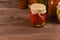 Canned pepper in glass jar in front of mixed marinated vegetables.