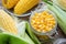 Canned sweet corn in glass jar, fresh and cooked corn on cobs.