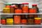 Canned vegetables and jams on refrigerator shelves