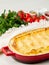 Cannelloni with filling of ricotta and parsley, baked with bÃ©chamel sauce, side view, vertical, white marble background