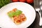Cannelloni on the plate on a wooden background