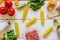 Cannelloni, tomatoes, minced meat and other ingredients. White wooden background. Italian cuisine