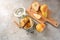 Canning pears with cinnamon and cloves in a glass jar, some fresh fruits on a cutting board, rustic gray stone background, copy