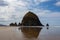 Cannon Beach, Oregon coast: the famous Haystack Rock reflects itself in the water