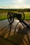 A cannon overlooking field with shadows cast on the ground