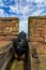 Cannon pointing through rampart toward the sea