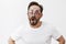 Cannot pick pair of glasses, all awesome. Portrait of funny adult playful man with beard and moustache putting on three