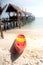 Canoe on the beach near traditional wooden bridge.