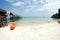 Canoe on the beach near traditional wooden bridge.