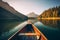 Canoe floating on a serene mountain lake surrounded by tall pine trees on a peaceful morning