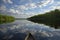 canoe on glassy lake, with reflections of trees and sky visible