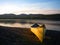 Canoe on lake shore at dusk.