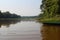 A canoe moored on a lake surrounded by grasses lining the Amazon rainforest in Tambopata, Peru