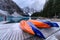 Canoe parked on wooden pier with rocky mountains in moraine lake at banff national park