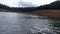 a canoe and raft paddling across a lake during a cloudy day