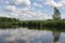 Canoeing in a kayak on Czarna Hancza virgin river in north-eastern Poland with blue sky, white clouds and green treas on a sunny s