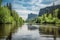 canoeist paddling down serene river, with incredible scenery in the background