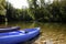 Canoes on the bank of a beautiful river with a background of trees and kayaks descending the river. sport and nature