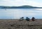 Canoes on sandy beach of calm lake with blue water and wooden island